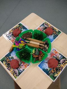 a wooden table topped with green plates filled with different types of food and decorations on top of it