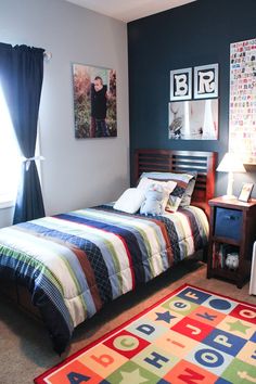 a bedroom with a bed, rug and pictures on the wall