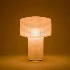 a white lamp sitting on top of a table next to a brown wall and floor