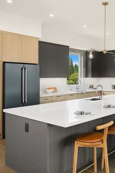 a large kitchen with an island and bar stools