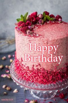 a birthday cake with pink frosting and sprinkles is on a glass plate