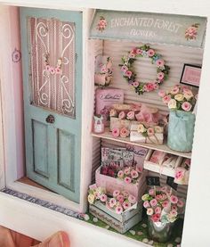 there is a doll house with pink flowers in the front and blue doors on the back