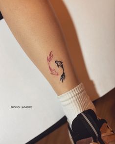 a woman's foot with a tattoo on her left leg, and a fish in the middle