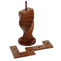 a wooden sculpture with four dominos in front of it and one piece missing from the base