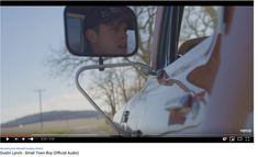 a man is seen in the rear view mirror of a car as he looks out the window