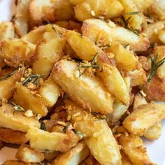 a white plate topped with fried potatoes covered in seasoning