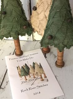 two fake trees are next to a book