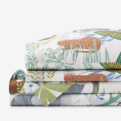 three sheets with giraffes and plants on them, all in different colors