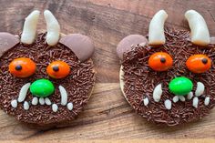 two cookies decorated to look like the faces of an animal with horns and carrots on them