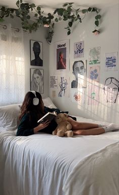 a woman laying on top of a bed next to a teddy bear with headphones