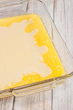 a glass dish filled with yellow liquid on top of a wooden table