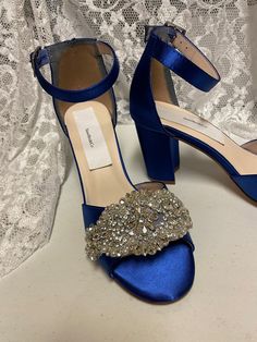 a pair of blue high heeled shoes with crystal embellishment