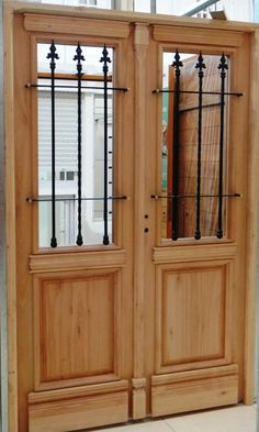 two wooden doors with wrought iron bars on them