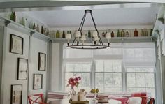 a dining room table with red chairs around it and a chandelier hanging from the ceiling