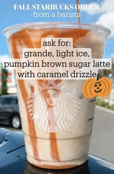 a cup of coffee sitting on top of a table next to a parking lot with the caption ask for grande, light ice pumpkin brown sugar latte with caramel driz