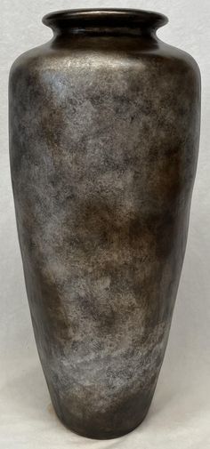 a black vase sitting on top of a white table