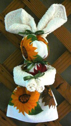 three towels stacked on top of each other with sunflowers and leaves attached to them