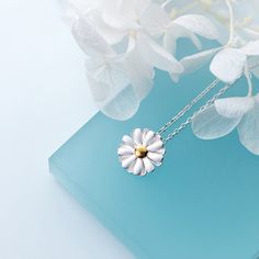 a white flower necklace sitting on top of a blue book