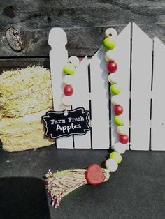 a white fence with a sign that says farm fresh apples hanging from it's side