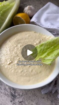 a white bowl filled with soup next to lettuce