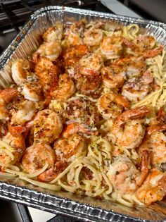 a pan filled with pasta and shrimp on top of a stove