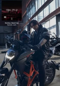 a man sitting on top of a motorcycle in front of a building with lots of windows