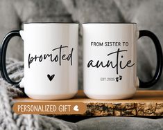 two personalized coffee mugs sitting on top of a wooden table next to a blanket