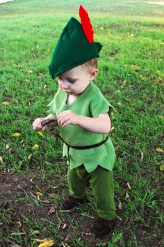 a little boy dressed up as peter the neverland elf holding a stick in his hand