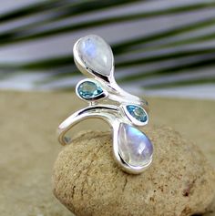 Prismatic Rainbow Fire Moonstone Ring is made of solid 925 sterling silver. The cabochon moonstone and faceted 3 x 5 pear shape Blue Topaz blue topaz are set in a sleek balance and they enhance each other's glimmer.Stylish Silver Ring is feminine beauty for your girl friend,This Genuine gemstone handmade silver Jewelry will be your adorable ring of your collection. SKU -2015-642 Style - Cocktail Gemstone - Rainbow Moonstone & Blue Topaz, Peridot Metal - 92.5 % Solid Sterling Silver Weight- 3.6 g June Gemstone, Chunky Jewellery, Silversmithing Jewelry, Jewelry Basket, Galaxy Jewelry, Fire Rainbow, Peridot Ring, Stone Setting, Moon Jewelry