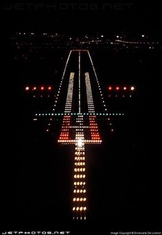 an aerial view of a runway at night with lights on it and the plane in the sky