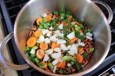 a pot filled with lots of vegetables on top of a stove