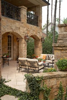 an outdoor living area with stone walls and patio furniture