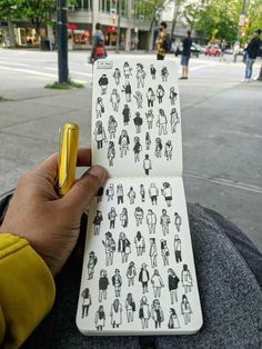 a person holding an open notebook with stickers on it and a pen in their hand