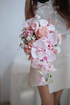 a woman holding a bouquet of pink flowers