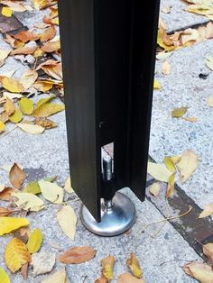 a metal pole on the ground with leaves around it and one door handle is open