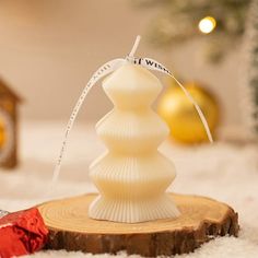 a white christmas tree ornament sitting on top of a piece of wood