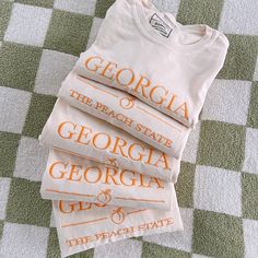 Georgia: The Peach State with a little peach doodle in a gorgeous orange thread against a neutral ivory tee. Brand: Comfort Colors, unisex fit Cute Peach T-shirt With Letter Print, Peach Doodle, Georgia Embroidery, Florida Georgia Line Shirts, Georgia Shirts, Georgia Sweatshirt, Georgia Shirt, Happy Tees