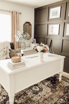 a living room filled with furniture and flowers on top of a white table in front of a window