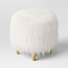 a white stool with wooden legs and fluffy fur