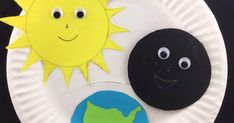 a paper plate that has some kind of sun and moon on it with the earth in front of it