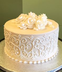 a white frosted cake with flowers on top