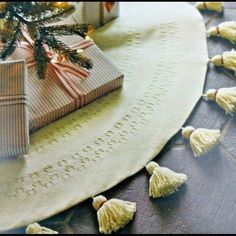 a christmas tree with presents on it and some tassels hanging from the top