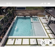 an aerial view of a swimming pool in a backyard with white tiles and green grass