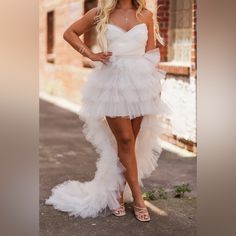 a woman in a white dress posing for the camera