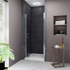 a bathroom with gray walls and marble flooring, including a walk in shower next to a plant