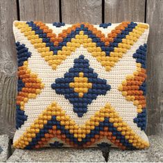 a pillow made out of beads sitting on top of a wooden bench