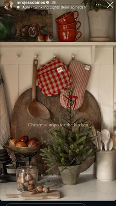 the kitchen is decorated for christmas with red and white checkered dishes on shelves above