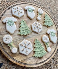 decorated cookies are arranged on a wooden platter