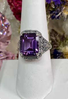 Inspired by Victorian/Edwardian era designs, I now offer this lovely filigree reproduction in sterling silver. This is a Natural Amethyst is 12mm by 10mm in size. The ring is 11/16th of an inch (17mm) NS on the finger. The inside of the band is etched 925. Notice the intricate and detailed floral design of the antique patina silver filigree setting all the way down the band. This is an exquisite rendition of an antique filigree ring. London Blue Topaz Earrings, Stock Design, Antique Filigree, Autumn Design, London Blue Topaz Ring, Blue Topaz Earrings, Purple Band, Filigree Design, Edwardian Era