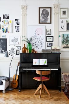 a living room filled with furniture and pictures on the wall next to a black piano